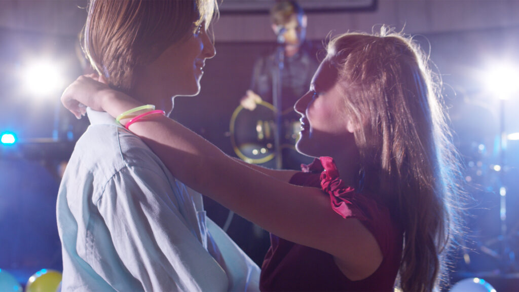 Winona Avenue Masterpiece music video thumbnail consisting of a boy and a girl dancing in front of the stage while the band performs.